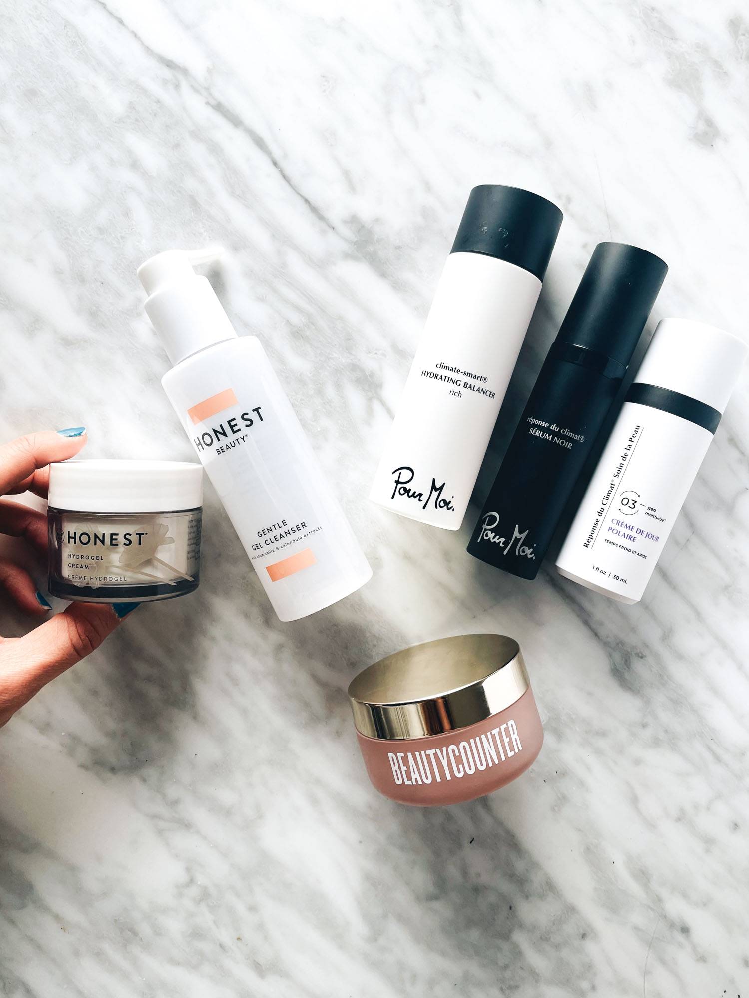 White hand holding skincare products